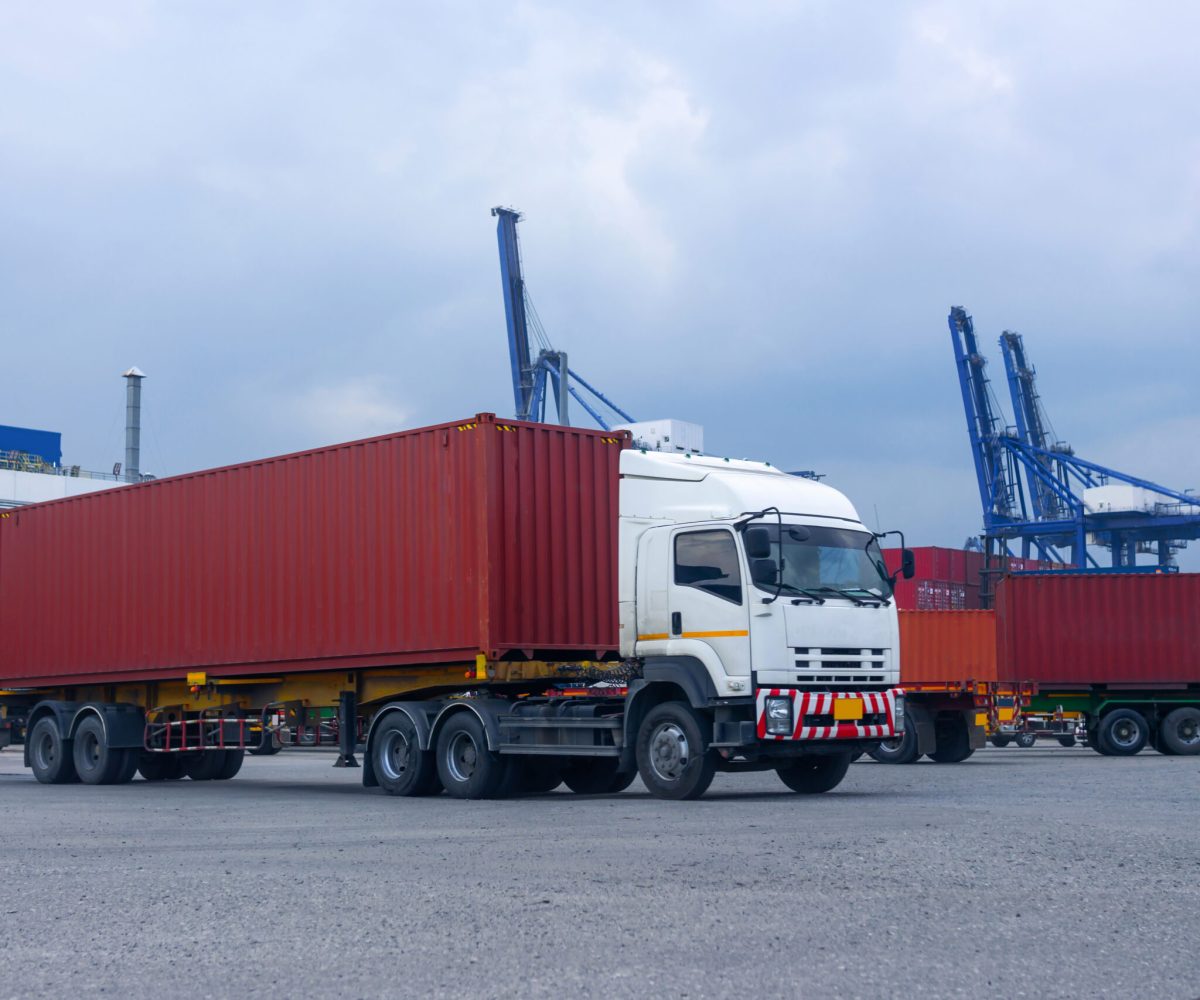 Container red truck in ship port Logistics.Transportation industry in port business concept.import,export logistic industrial Transporting Land transport freight warehouse storge